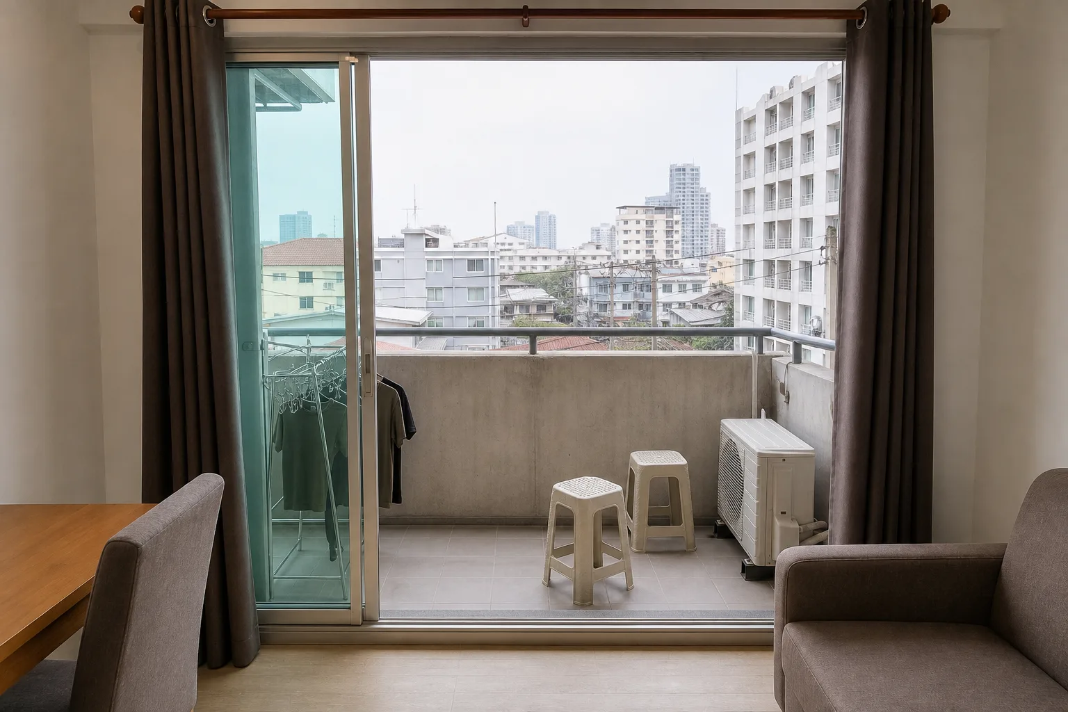 The balcony of the one bedroom, with a drying rail and a view over the soi