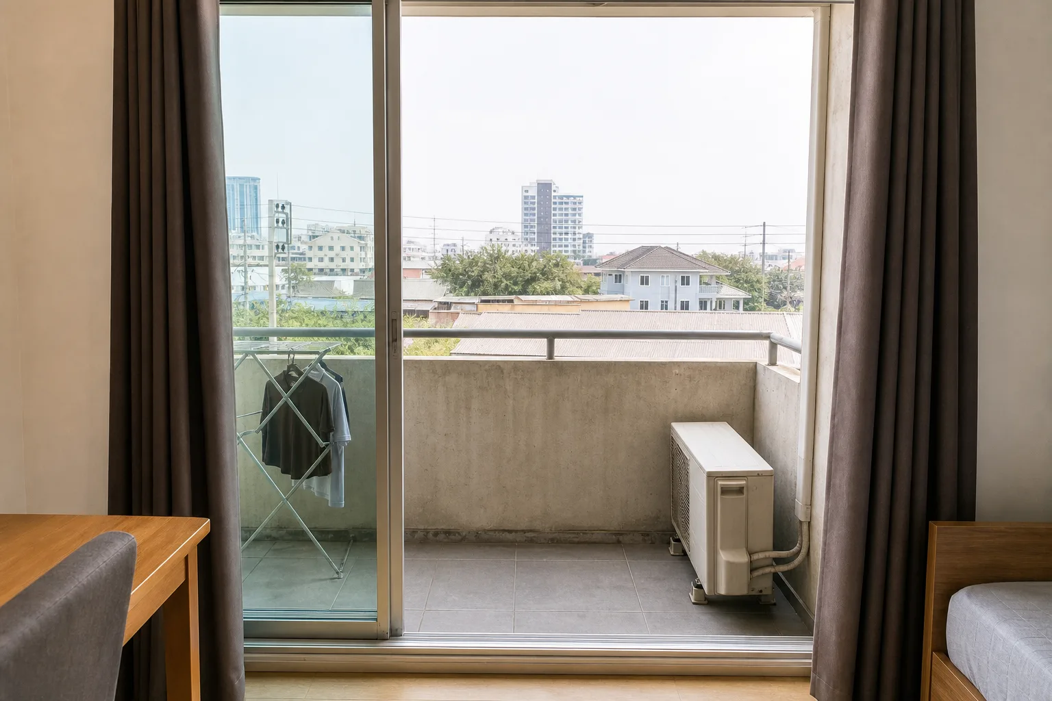 The balcony of the studio, with a drying rail and a view over the soi
